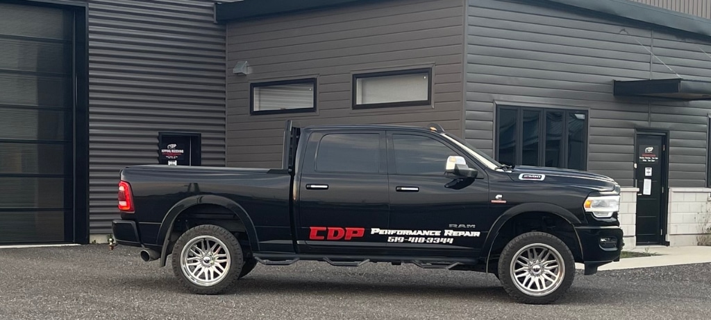 Truck Repair in Palmerston, ON at CDP Diesel and Auto. Image of a Black Ram 1500 with a sticker of CDP Performance Repair parked outside the shop of CDP Diesel & Auto.