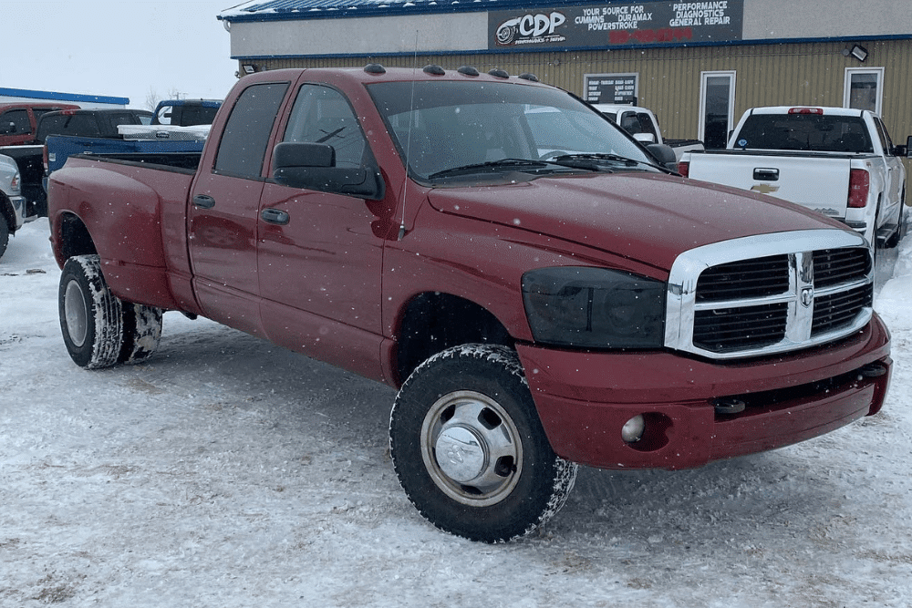 Winter tire installation, auto repair in Palmerston, ON by CDP Diesel & Auto. Image of a red diesel pickup truck parked in snowy conditions outside the shop, highlighting reliable diesel diagnostics and repair services built to handle winter driving and heavy-duty performance needs.