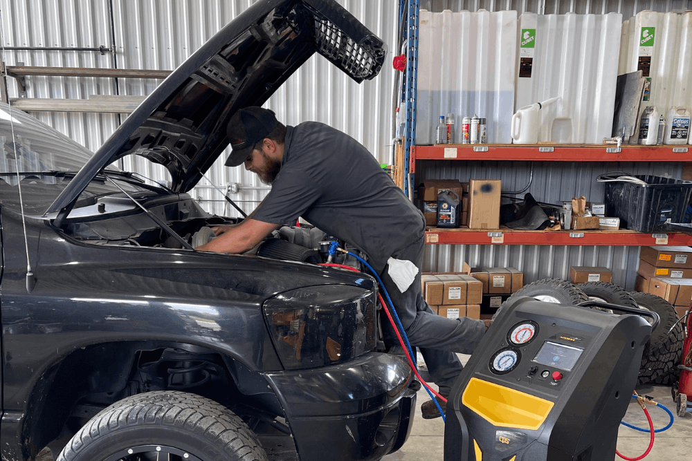 Auto a/c repair, auto repair in Palmerston, ON, at CDP Diesel & Auto INC. An image of an auto technician performing automotive A/C repair and air conditioning service on a pickup truck using professional refrigerant recovery and recharge equipment.